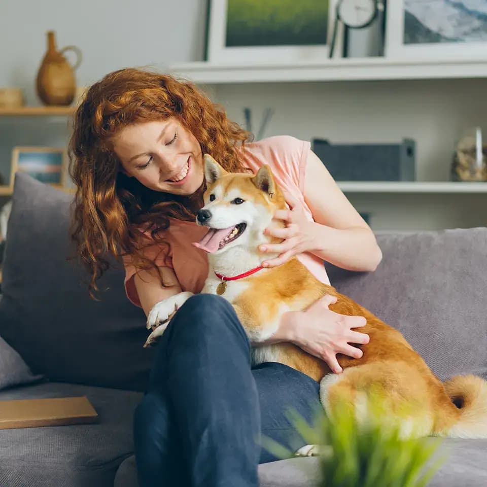 Women sitting on couch with a dog