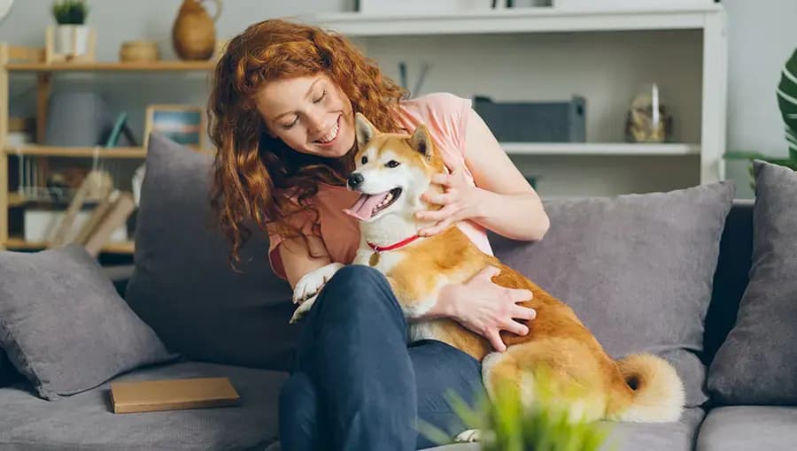 Women sitting on couch with a dog